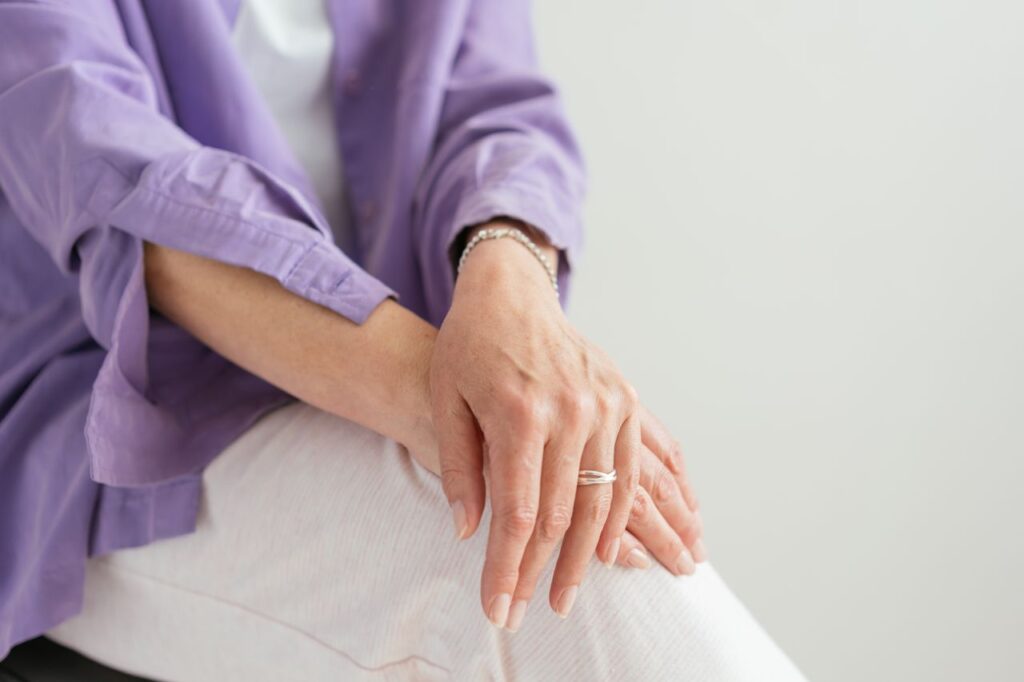 Relaxed hands resting on the knee, in soft natural light